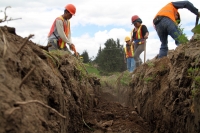 Trabajadores cubren la tubería de conducción del agua